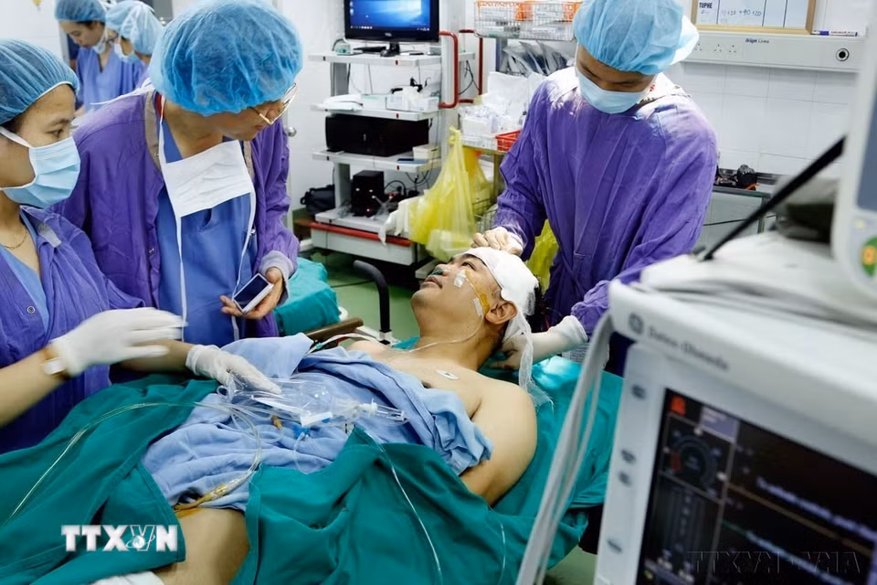 Phó Giáo sư-Tiến sỹ Đồng Văn Hệ, Phó Giám đốc bệnh viện Hữu nghị Việt Đức nói chuyện bình thường với bệnh nhân ngay trên bàn mổ, sau khi thực hiện ca phẫu thuật u não bằng phương pháp “Mổ thức tỉnh” lần đầu tiên tại Việt Nam năm 2019. (Ảnh: Dương Ngọc/TTXVN)