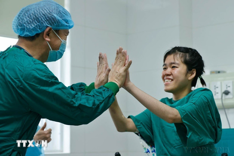 Niềm vui của bác sỹ và bệnh nhân P.A.T (phải) khi sức khỏe tiến triển tốt, hồi phục nhanh sau ca ghép phổi. Sự thành công của ca ghép phổi là thành tựu tiêu biểu của ngành y tế Việt Nam, góp phần mang lại những giá trị to lớn cho sức khỏe người bệnh và nhân dân. (Ảnh: Minh Quyết/TTXVN)