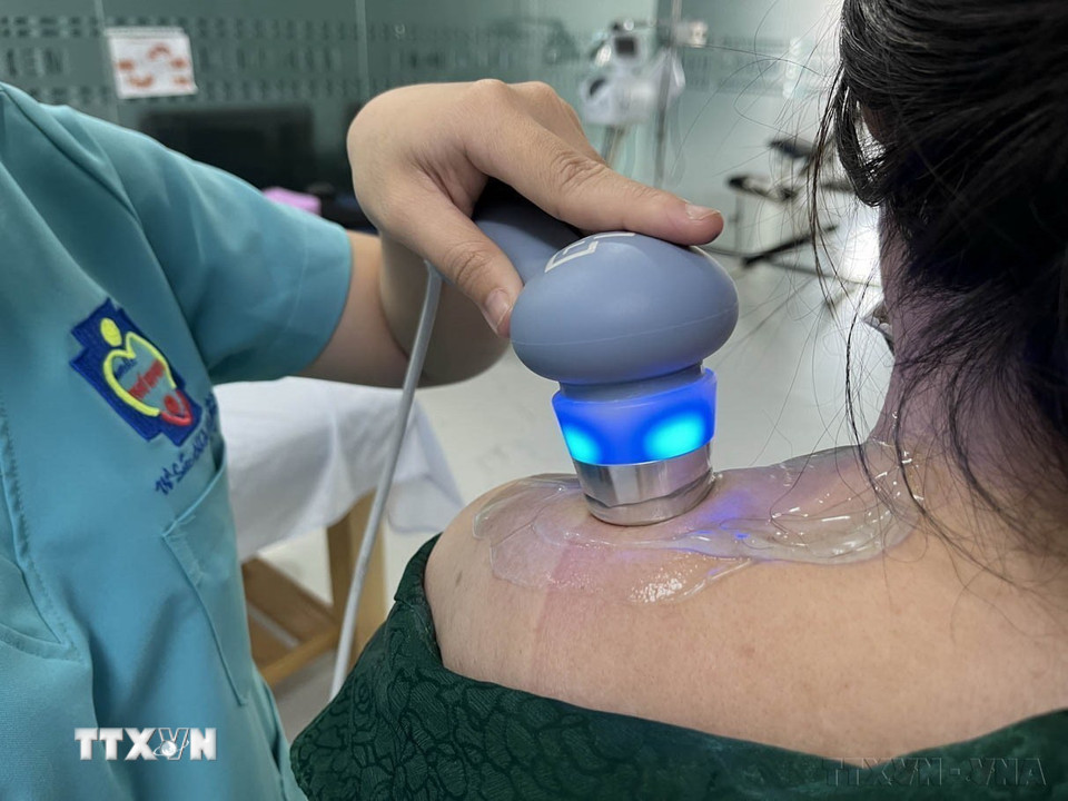 Nhân viên y tế tỉnh Long An điều trị đau nhức, tê bì vùng vai cho bệnh nhân bằng máy xung điện. Điều trị phục hồi hướng tới không dùng thuốc là xu thế mới đang được ngành y tế hiện nay khuyến khích. (Ảnh: Đức Hạnh/TTXVN)