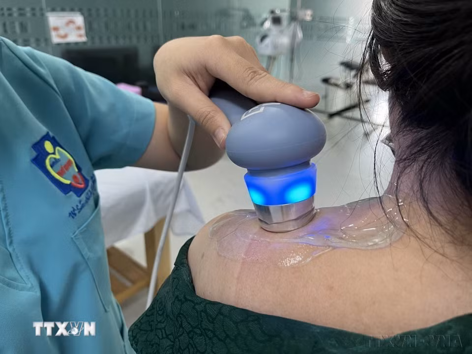 Nhân viên y tế tỉnh Long An điều trị đau nhức, tê bì vùng vai cho bệnh nhân bằng máy xung điện. Điều trị phục hồi hướng tới không dùng thuốc là xu thế mới đang được ngành y tế hiện nay khuyến khích. (Ảnh: Đức Hạnh/TTXVN)