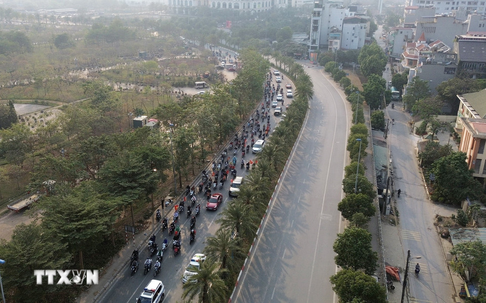 Cổ động viên đi theo đoàn xe chở đội tuyển bóng đá Việt Nam từ sân bay Nội Bài về thành phố. (Ảnh: Quốc Khánh/TTXVN)