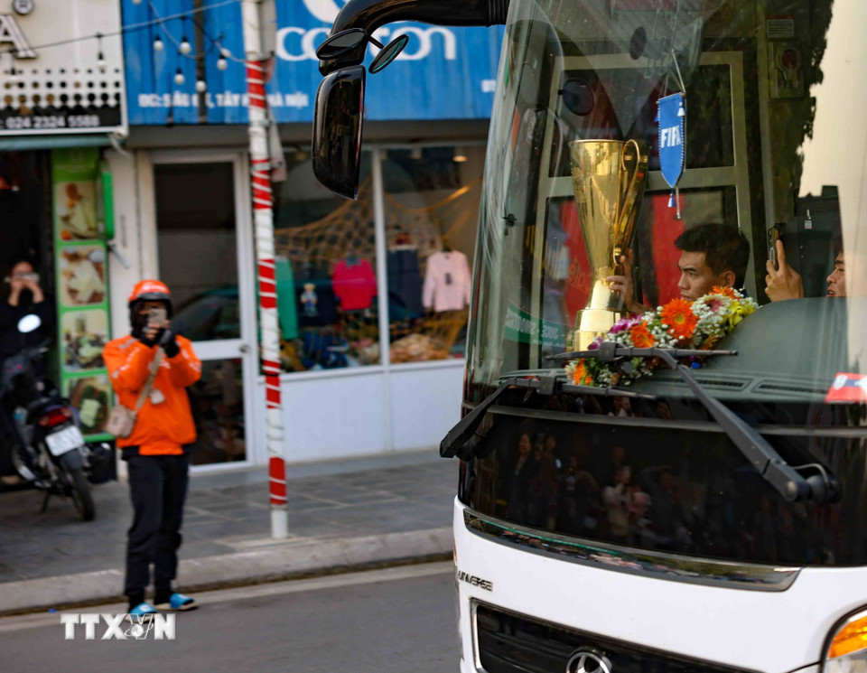 Người hâm mộ chào đón đội tuyển bóng đá Việt Nam cùng chiếc cúp vô địch ASEAN Cup 2024 dọc bên đường Âu Cơ. (Ảnh: Thanh Tùng/TTXVN)