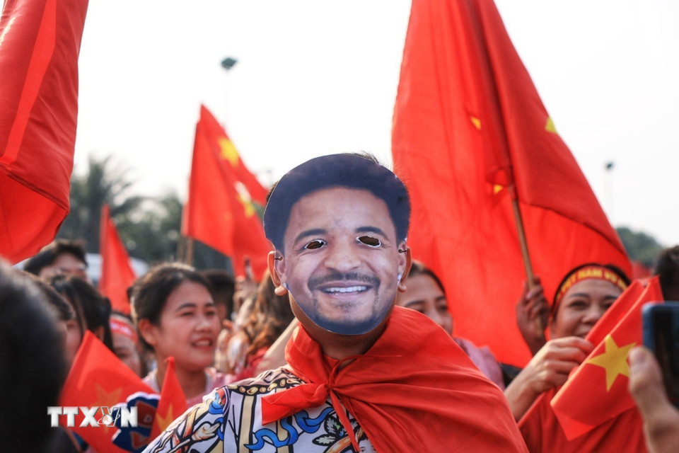 Người hâm mộ mang theo ảnh cầu thủ Nguyễn Xuân Son đến chào mừng đội tuyển. (Ảnh: Tuấn Anh/TTXVN)