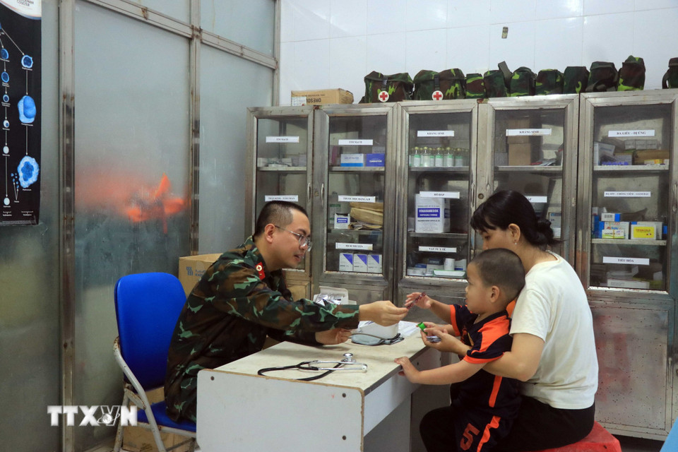 Bác sỹ tại Bệnh xá Quân y đảo Song Tử Tây tư vấn, cấp thuốc cho người dân. (Ảnh: Hữu Quyết/TTXVN)