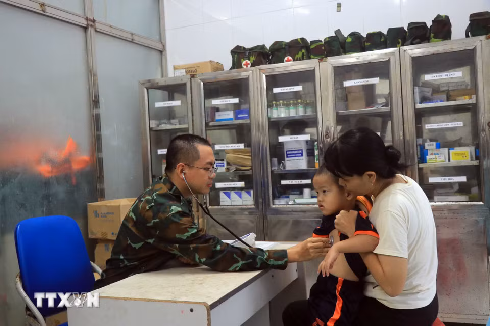 Bác sỹ tại Bệnh xá Quân y đảo Song Tử Tây thăm khám bệnh cho trẻ em trên đảo. (Ảnh: Hữu Quyết/TTXVN)