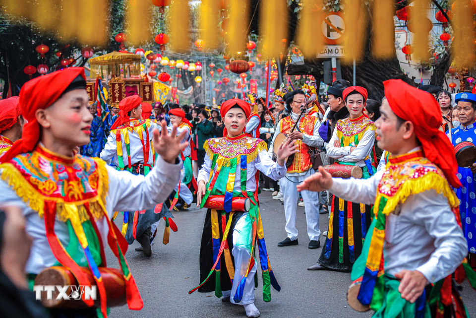 Các trai làng đóng giả làm con gái, má phấn, môi son, đầu chít khăn mỏ quạ, váy nhiễu màu đen với những dải màu ngũ sắc biểu diễn điệu múa "Con đĩ đánh bồng" trong lễ hội. (Ảnh: Hoàng Hiếu/TTXVN)