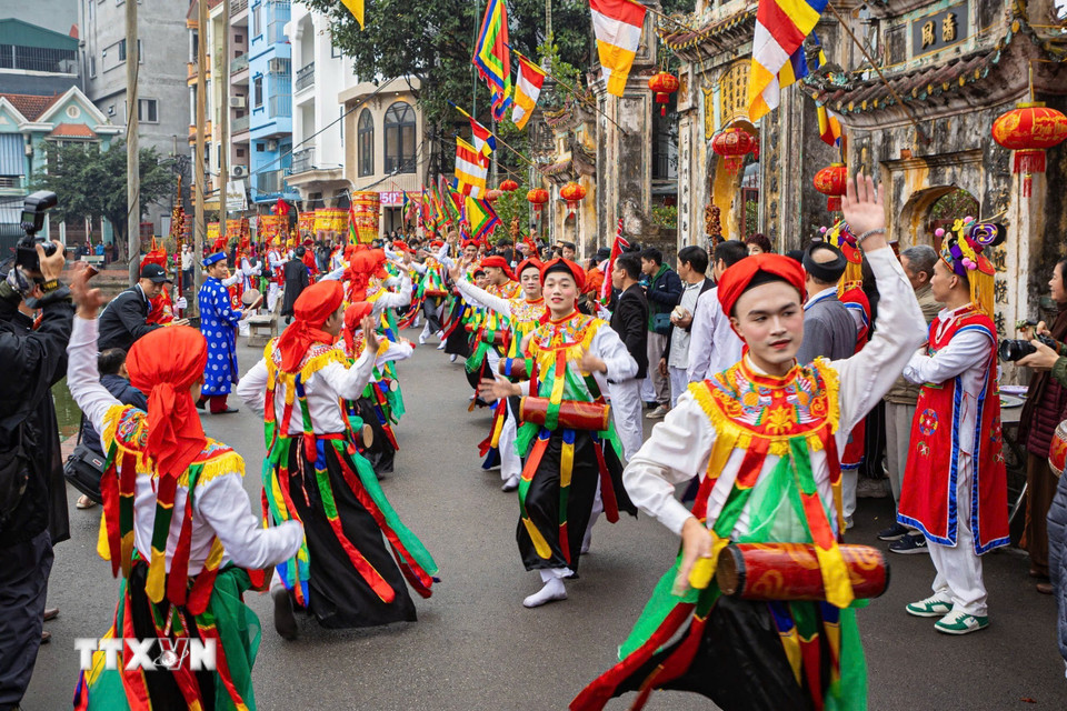 Ngoài lễ rước Vua, tâm điểm Lễ hội làng Triều Khúc là điệu múa "Con đĩ đánh bồng" - điệu múa cổ do trai làng đóng giả gái với má phấn, môi son, đầu chít khăn mỏ quạ, váy nhiễu màu đen với những dải màu ngũ sắc, vừa múa nhún nhảy, vừa vỗ trống bồng. (Ảnh: Phạm Tuấn Anh/TTXVN)