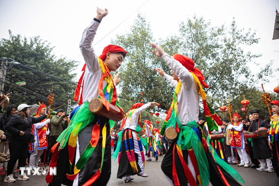 Ngoài lễ rước Vua, tâm điểm Lễ hội làng Triều Khúc là điệu múa "Con đĩ đánh bồng" - điệu múa cổ do trai làng đóng giả gái với má phấn, môi son, đầu chít khăn mỏ quạ, váy nhiễu màu đen với những dải màu ngũ sắc, vừa múa nhún nhảy, vừa vỗ trống bồng. (Ảnh: Phạm Tuấn Anh/TTXVN)