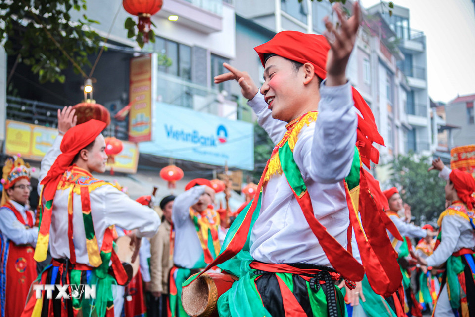 Các trai làng đóng giả làm con gái, má phấn, môi son, đầu chít khăn mỏ quạ, váy nhiễu màu đen với những dải màu ngũ sắc biểu diễn điệu múa "Con đĩ đánh bồng" trong lễ hội. (Ảnh: Hoàng Hiếu/TTXVN)