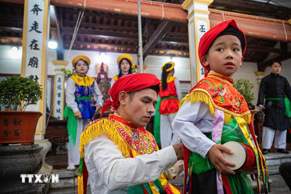 Thành viên CLB trống bồng Triều Khúc hướng dẫn, chuẩn bị trống bồng cho các em nhỏ trước khi tham gia biểu diễn. (Ảnh: Phạm Tuấn Anh/TTXVN)