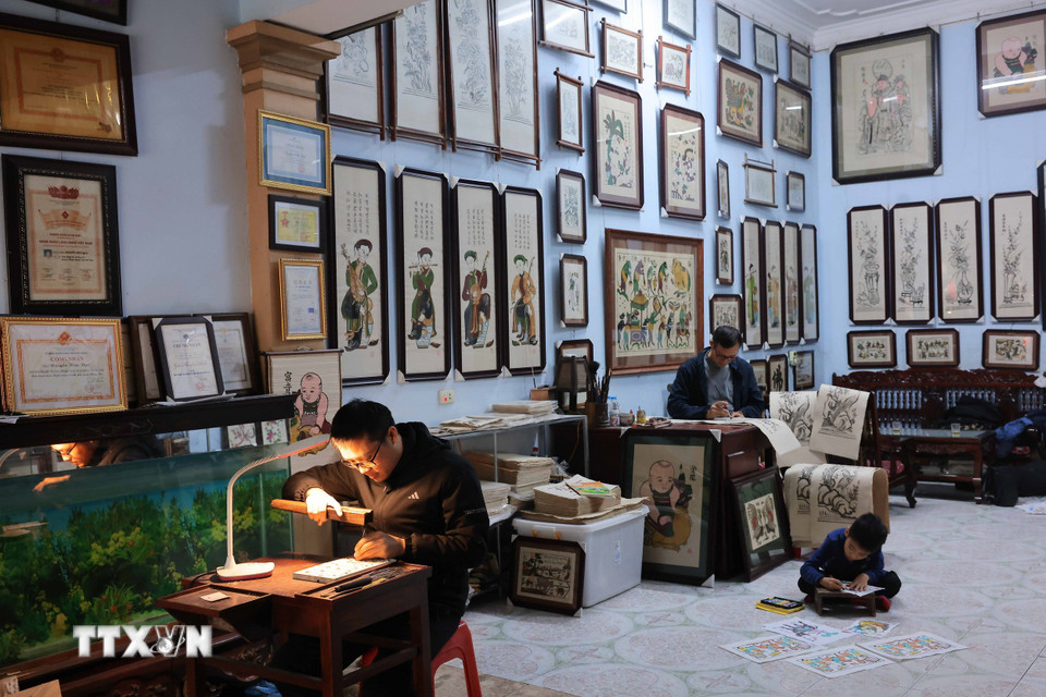 Ba thế hệ của gia đình nghệ nhân Ưu tú Nguyễn Hữu Quả - một trong rất ít gia đình vẫn còn làm nghề, gắn bó với nghề truyền thống lâu đời tranh dân gian Đông Hồ. (Ảnh: Hoàng Hiếu/TTXVN)