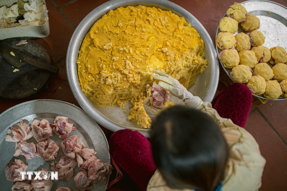 Công đoạn nắm đậu và thịt để làm nhân bánh chưng Tranh Khúc. (Ảnh: Phạm Tuấn Anh/TTXVN)