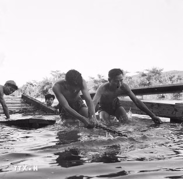 Đại đội công binh bến phà D, đơn vị quyết thắng tỉnh Quảng Bình chuẩn bị cầu phà chắc chắn để đưa xe qua sông nhanh chóng, an toàn, tháng 6/1968. (Ảnh: Nghĩa Dũng/TTXVN)