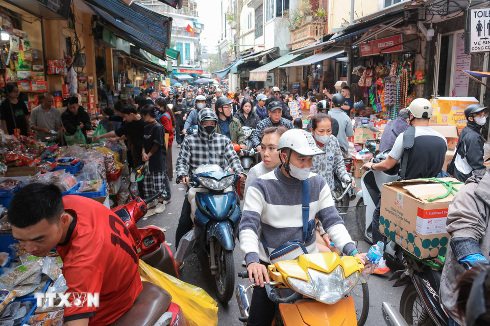 Nhiều người dân đến mua sắm bánh kẹo khiến phố Hàng Giầy bị ùn tắc cục bộ. (Ảnh: Hoàng Hiếu/TTXVN)