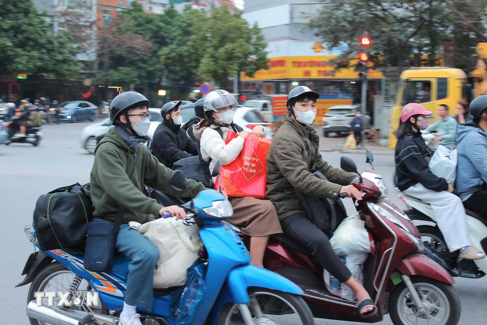 Nhiều người dân với hành lý chằng, buộc cẩn thận di chuyển từ cửa ngõ phía Nam rời Thủ đô. (Ảnh: Hoàng Hiếu/TTXVN)