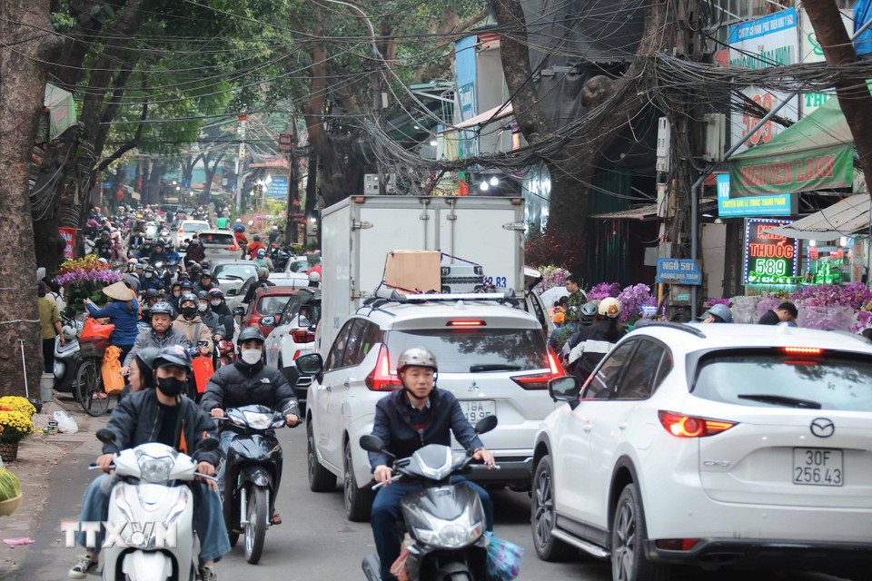 Nhiều người dân và phương tiện di chuyển trên phố Hoàng Hoa Thám vào chiều 25/1. (Ảnh: Hoàng Hiếu/TTXVN)