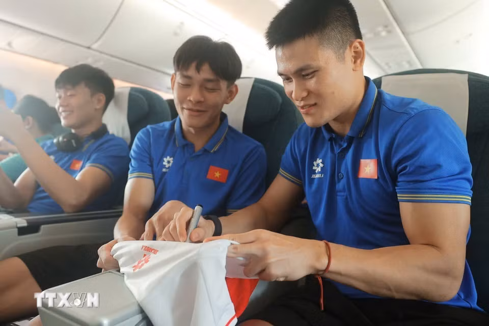 Tuấn Hải ký tặng cho đồng đội khi máy bay vừa hạ cánh. (Ảnh: Minh Quyết/TTXVN)