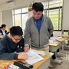 Thầy Nguyễn Đăng Lâm hướng dẫn học sinh làm bài. (Ảnh: PM/Vietnam+).