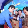 Bí thư Thứ nhất Trung ương Đoàn Bùi Quang Huy tặng quà cho người dân hoàn cảnh khó khăn, gia đình chính sách.(Ảnh: PV/Vietnam+).