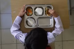 Một học sinh ăn trưa vào ngày đầu tiên của chương trình bữa ăn miễn phí tại một trường tiểu học ở Indonesia. (Nguồn: CNN)
