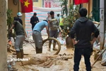 Người dân và công nhân được huy động nhằm khắc phục sự cố tràn bùn. (Ảnh: Minh Hiếu/Vietnam+)