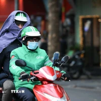 Người dân che chắn chống rét khi phải di chuyển trên đường. (Ảnh: Hoàng Hiếu/TTXVN)