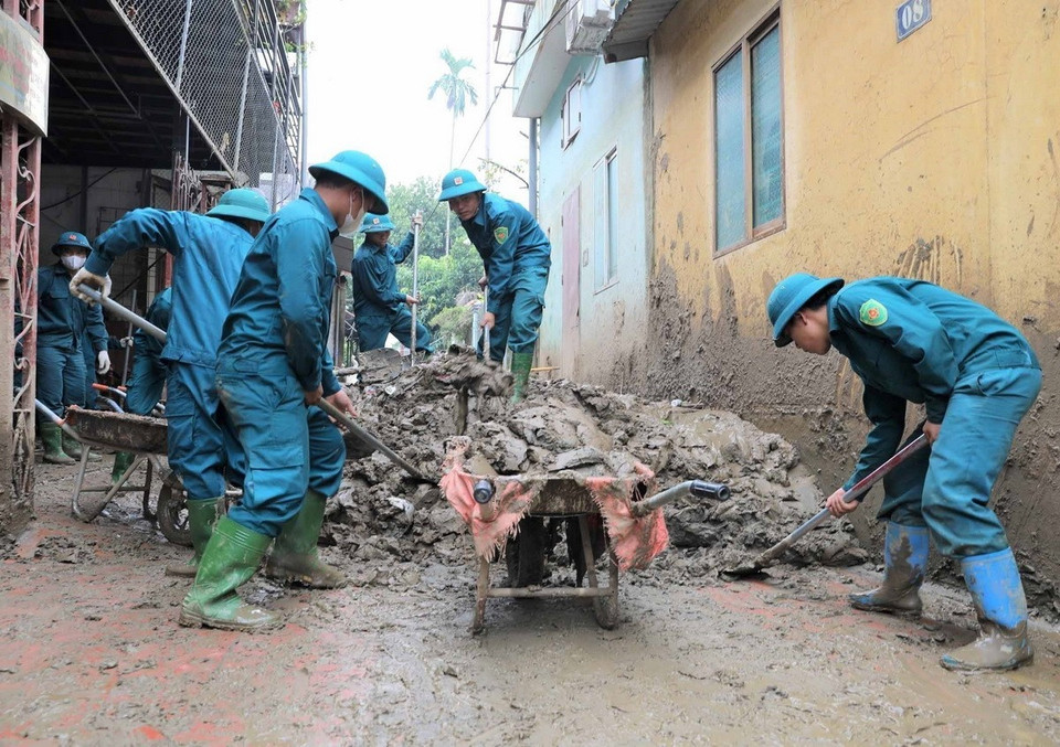 Lực lượng dân quân tự vệ tham gia khắc phục, thu dọn vệ sinh sau khi nước rút tại thành phố Yên Bái. (Ảnh: Tuấn Anh/TTXVN)