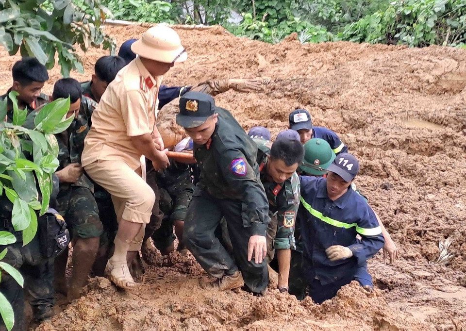 Các lực lượng chức năng đưa thi thể nạn nhân trong vụ sạt lở đất trên quốc lộ 34 làm 11 người chết tại tỉnh Hà Giang. (Ảnh: Đức Thọ/TTXVN)