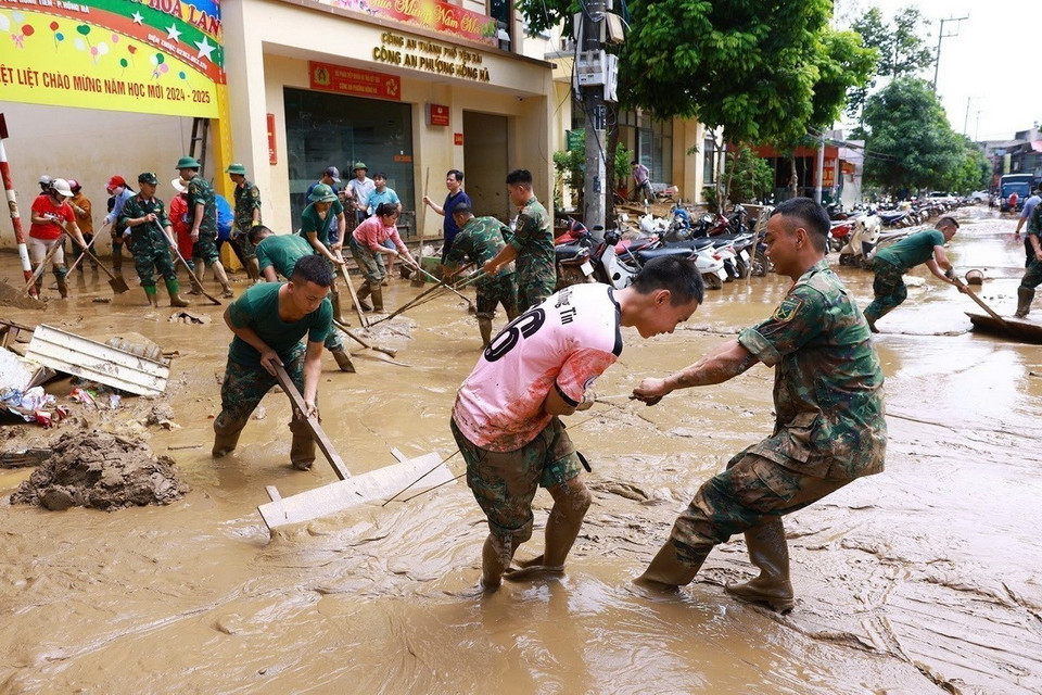 Bộ đội giúp nhân dân thành phố Yên Bái dọn dẹp bùn đất sau lũ quét. (Ảnh: Dương Giang/TTXVN)