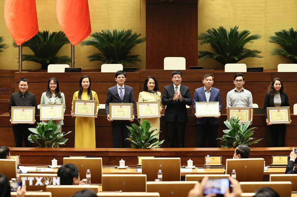 Phó Chủ nhiệm Thường trực Văn phòng Quốc hội Phạm Đình Toản trao Bằng khen của Chủ nhiệm Văn phòng Quốc hội cho các cá nhân. (Ảnh: An Đăng/TTXVN)