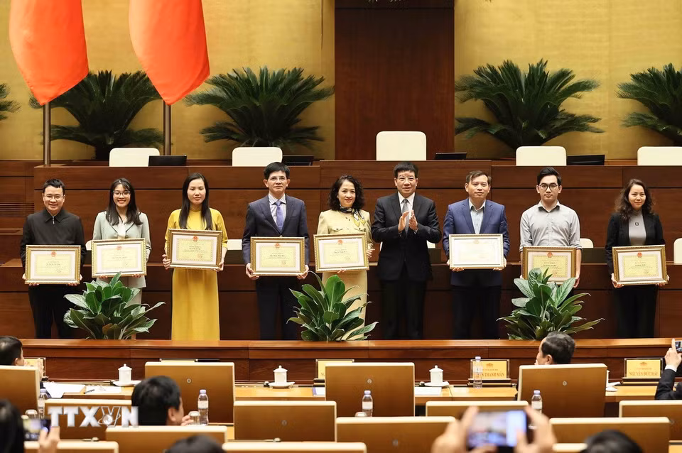 Phó Chủ nhiệm Thường trực Văn phòng Quốc hội Phạm Đình Toản trao Bằng khen của Chủ nhiệm Văn phòng Quốc hội cho các cá nhân. (Ảnh: An Đăng/TTXVN)