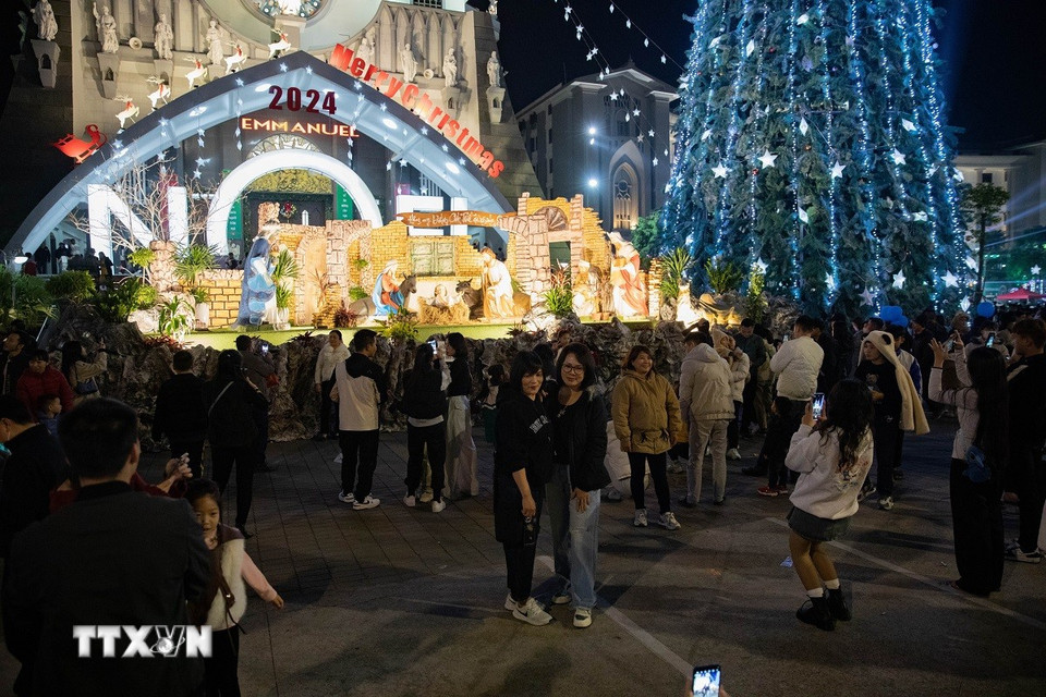 Người dân đến tham quan, chụp ảnh tại Nhà thờ Chính Tòa (thành phố.Thái Bình). (Ảnh: Vũ Quang/TTXVN)
