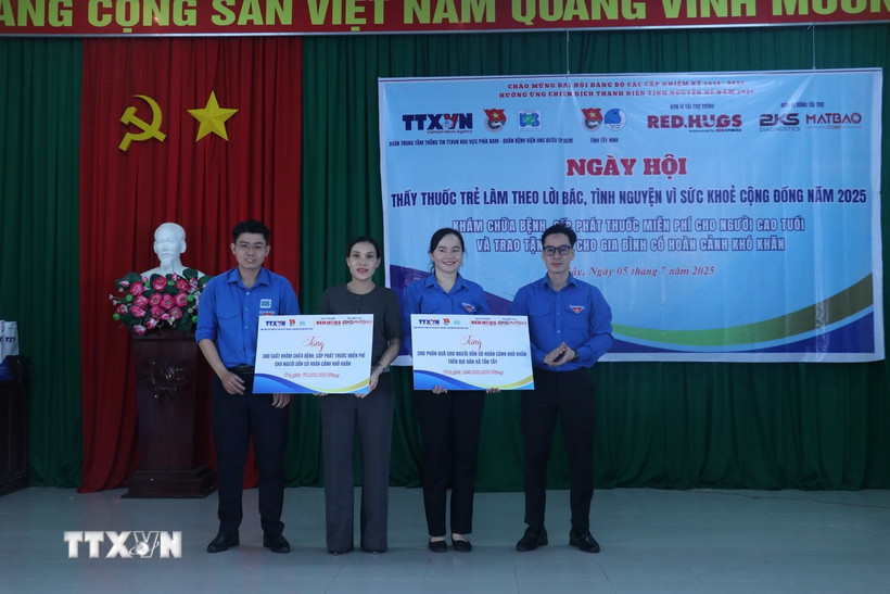 Đại diện Đoàn Thanh niên Trung tâm thông tin TTXVN khu vực phía Nam, Đoàn thanh niên Bệnh viện Ung bướu Thành phố Hồ Chí Minh trao bảng quà tượng trưng cho chính quyền địa phương. (Ảnh: Bùi Giang/ TTXVN)