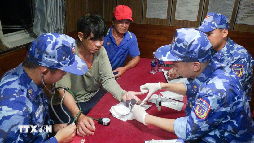 Cán bộ, chiến sỹ tàu cảnh sát biển 4035, Bộ Tư lệnh Vùng Cảnh sát biển 4 chăm sóc, hỗ trợ y tế cho nạn nhân gặp nạn trên biển. (Ảnh: TTXVN phát)