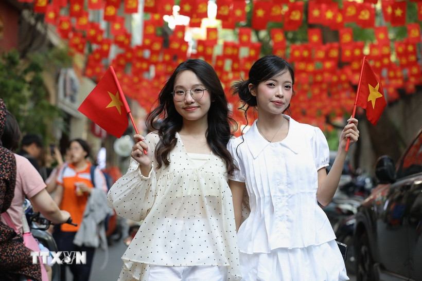 Phố Ấu Triệu với những dải cờ đỏ sao vàng tung bay, thu hút đông đảo bạn trẻ đến chụp ảnh để hòa chung không khí kỉ niệm dịp lễ 30/4. (Ảnh: Lê Đông/TTXVN)