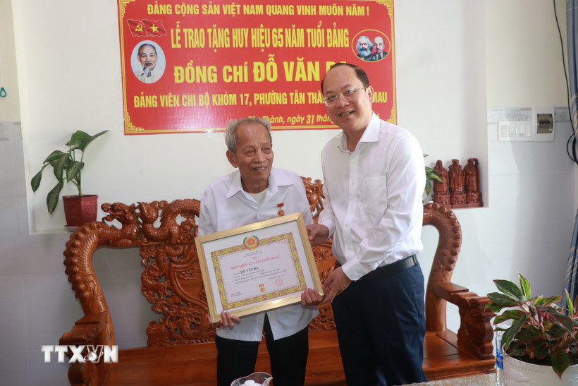Bí thư Tỉnh ủy Cà Mau Nguyễn Hồ Hải trao Huy hiệu 65 năm tuổi Đảng cho đồng chí Đỗ Văn Ba. (Ảnh: Huỳnh Anh/TTXVN)