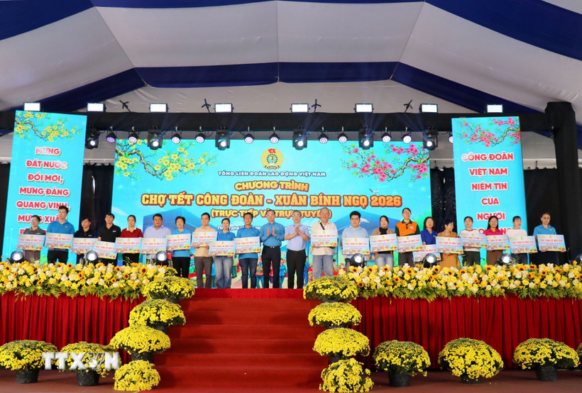 Ông Nguyễn Đình Khang, Chủ tịch Tổng Liên đoàn Lao động Việt Nam và ông Nguyễn Phước Lộc, Phó Bí thư Thành ủy Thành phố Hồ Chí Minh trao tặng vé máy bay cho công nhân lao động về quê đón Tết. (Ảnh: Thanh Vũ/TTXVN)