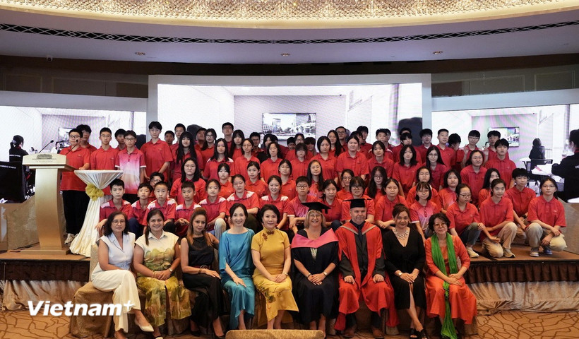 Bà Maggie Xia, Hiệu trưởng (hàng đầu, ngồi giữa, áo đầm vàng) và các thầy cô chụp lưu niệm cùng các em học sinh khoá học Singapore Cambridge O-Level. (Nguồn: Vietnam+)