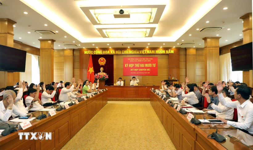 Các đại biểu Hội đồng Nhân dân tỉnh Vĩnh Phúc biểu quyết thông qua các nghị quyết của kỳ họp. (Ảnh: Hoàng Hùng/TTXVN)