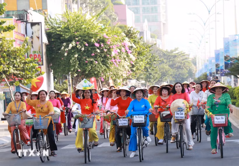 Phụ nữ Khánh Hòa tham gia lễ hội diễu hành áo dài bằng xe đạp. (Ảnh: Phan Sáu/TTXVN)