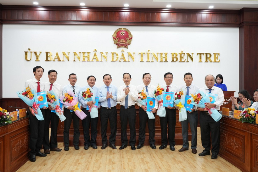 Trao Nghị quyết của Hội đồng Nhân dân tỉnh Bến Tre cho đại diện các cơ quan hợp nhất, sáp nhập. (Ảnh: Huỳnh Phúc Hậu/TTXVN)