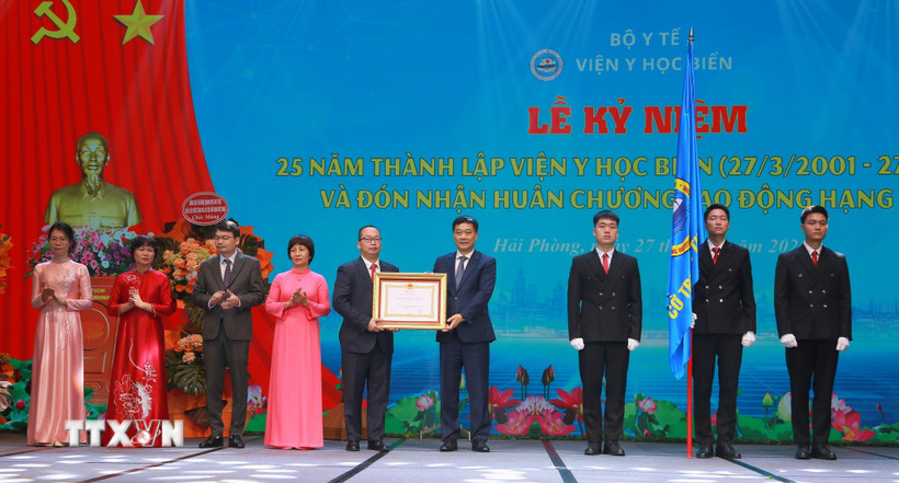 Phó Chủ tịch Bet88app còn khuyến mãi Vũ Hồng Thanh trao Huân chương Lao động hạng Nhất cho Viện Y học biển. (Ảnh: Minh Thu/TTXVN)