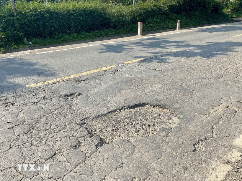 Mặt đường Hồ Chí Minh đoạn qua xã Hương Long (huyện Hương Khê, tỉnh Hà Tĩnh) bị bong tróc. (Ảnh: Hữu Quyết/TTXVN)