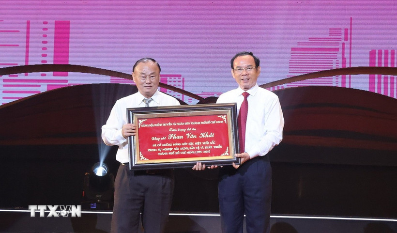 Bí thư Thành ủy TP Hồ Chí Minh Nguyễn Văn Nên trao bảng tôn vinh cho gia đình cố Thủ tướng Chính phủ Phan Văn Khải. (Ảnh: Hữu Duyên/ TTXVN)