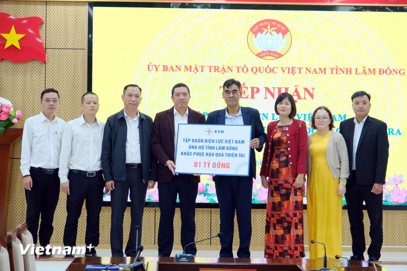 Ông Phan Sỹ Duy, Giám đốc Công ty Điện lực Lâm Đồng (người trao bảng bên trái) trao 1 tỷ đồng cho ông Bon Yô Soan, Phó Chủ tịch Ủy ban Mặt trận Tổ quốc Việt Nam tỉnh Lâm Đồng. (Ảnh: PV/Vietnam+)