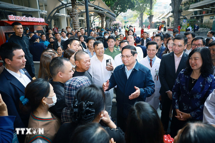 Thủ tướng Phạm Minh Chính thăm hỏi, chúc Tết người thân bệnh nhân điều trị tại Bệnh viện Bạch Mai. (Ảnh: Dương Giang/TTXVN)