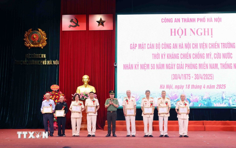 Thiếu tướng Nguyễn Thanh Tùng, Giám đốc Công an thành phố Hà Nội trao Giấy khen cho các đồng chí có nhiều đóng góp trong hoạt động của Ban liên lạc chiến trường B,C,K. (Ảnh: Phạm Kiên/TTXVN)