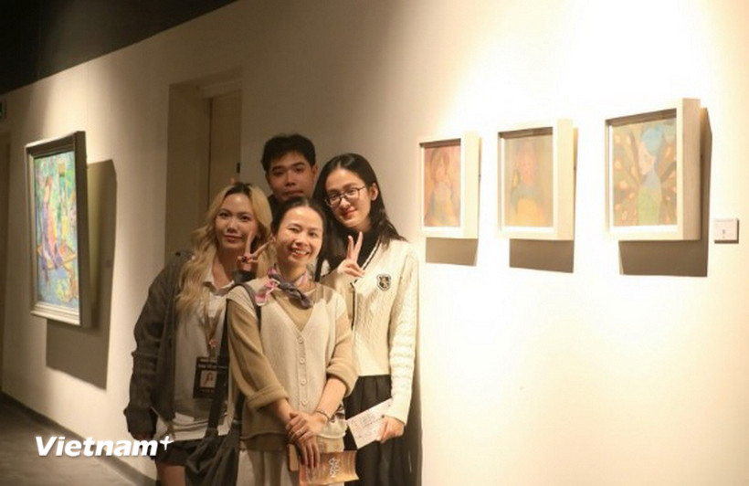 Võ Đình Lân và Vũ Yến Nhi - Ban Tổ chức triển lãm “Nữ Thời” - chụp ảnh cùng 2 họa sỹ. (Nguồn: Vietnam+)