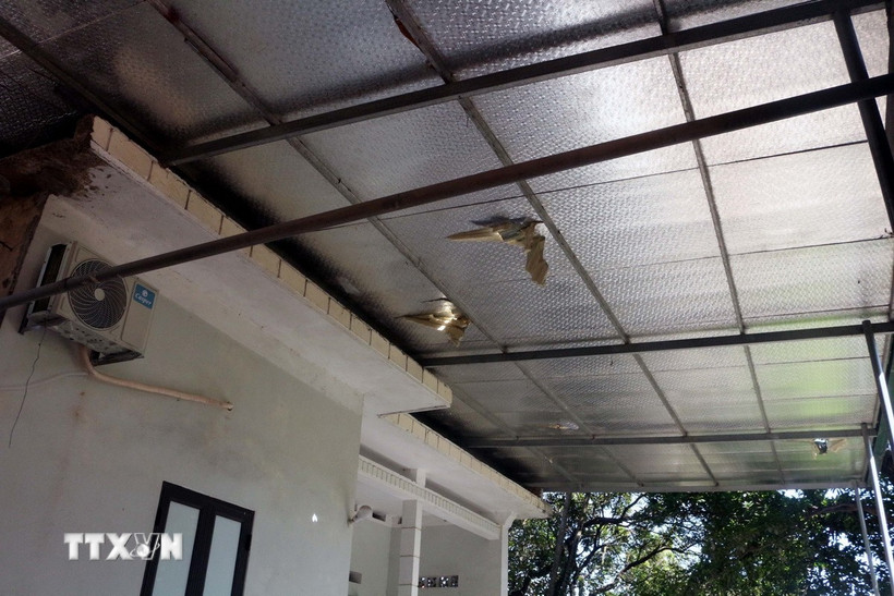 Hộ gia đình bà Lê Thị Ly bị đất đá làm sập tường rào phía sau nhà, mái ngói, mái tôn bị đá rơi vỡ làm thủng nhiều chỗ. (Ảnh: Đại Nghĩa/ TTXVN)