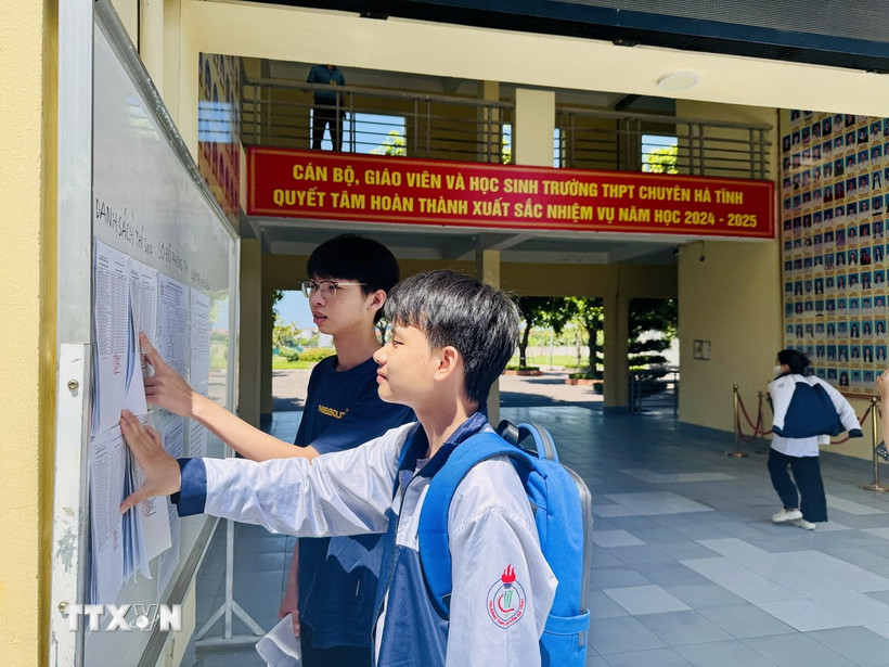 Thí sinh kiểm tra thông tin, số báo danh và sơ đồ phòng thi tại điểm thi Trường THPT Chuyên Hà Tĩnh. (Ảnh: Hoàng Ngà/TTXVN)